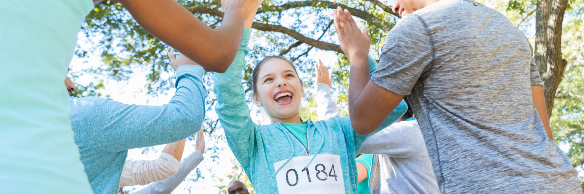 Group of smiling people high fiving after a charity run